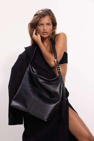 The Brynn Leather Tote in Black/Gold on a Model 2